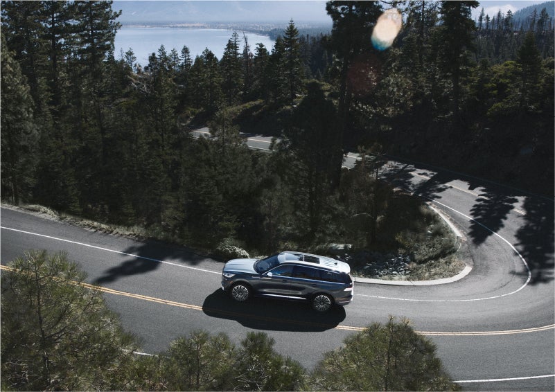 A 2023 Lincoln Aviator® SUV is being driven on a winding mountain road | Star Lincoln in Southfield MI