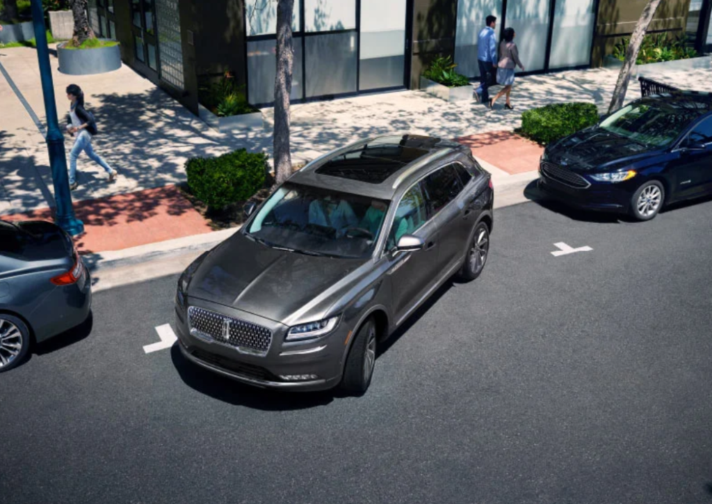 A gray 2023 Lincoln Nautilus pulling out of a parallel parking spot.