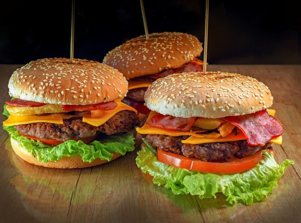 Three burgers held together with sticks through the center.