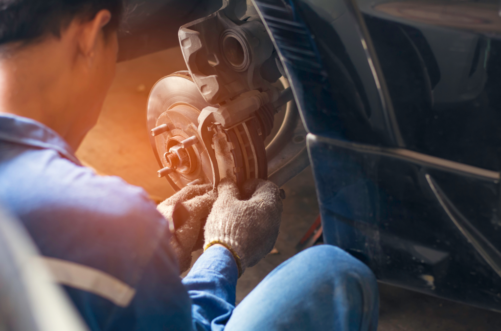 A service technician fixing brakes on a car.