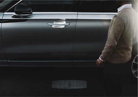 A person approaches a 2023 Lincoln Aviator® Grand Touring as the Lincoln Embrace sequence of welcome lighting illuminates | Star Lincoln in Southfield MI
