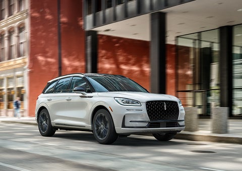 The 2024 Lincoln Corsair® SUV with the Jet Appearance Package and a Pristine White exterior is parked on a city street. | Star Lincoln in Southfield MI