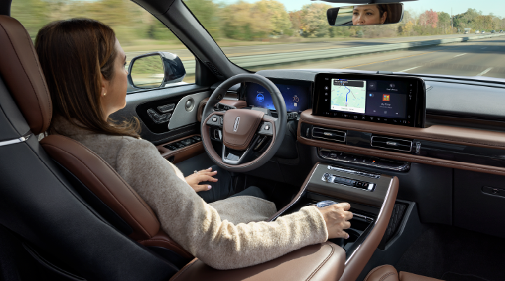 A woman is seen sitting in the driver’s seat of her 2025 Lincoln Aviator® SUV with her hands off the steering wheel. | Star Lincoln in Southfield MI