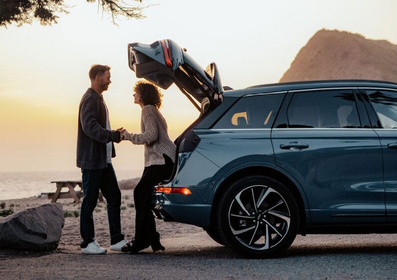 A couple share a moment together outside a 2025 Lincoln Corsair® SUV near the open liftgate. | Star Lincoln in Southfield MI