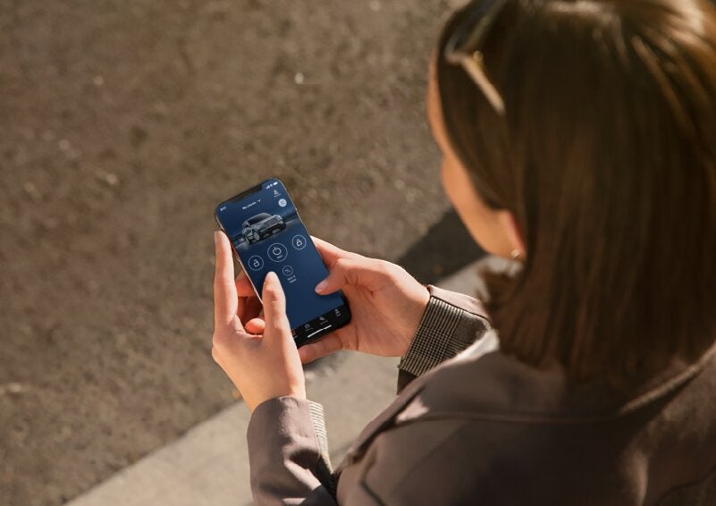 A person is shown interacting with a smartphone to connect to a Lincoln vehicle via the Lincoln Way® App. | Star Lincoln in Southfield MI