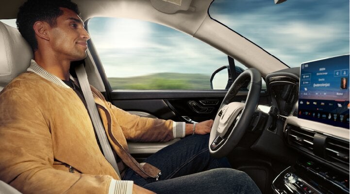 A person is shown using Lincoln BlueCruise hands-free highway driving technology on a divided highway called a Hands-Free Blue Zone. | Star Lincoln in Southfield MI