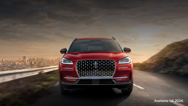 A 2025 red Lincoln Corsair® SUV is being driven down a road at sunset. | Star Lincoln in Southfield MI