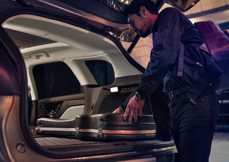 A man is shown loading cargo into the rear of a 2024 Lincoln Corsair® SUV with the second-row seats folded flat. | Star Lincoln in Southfield MI