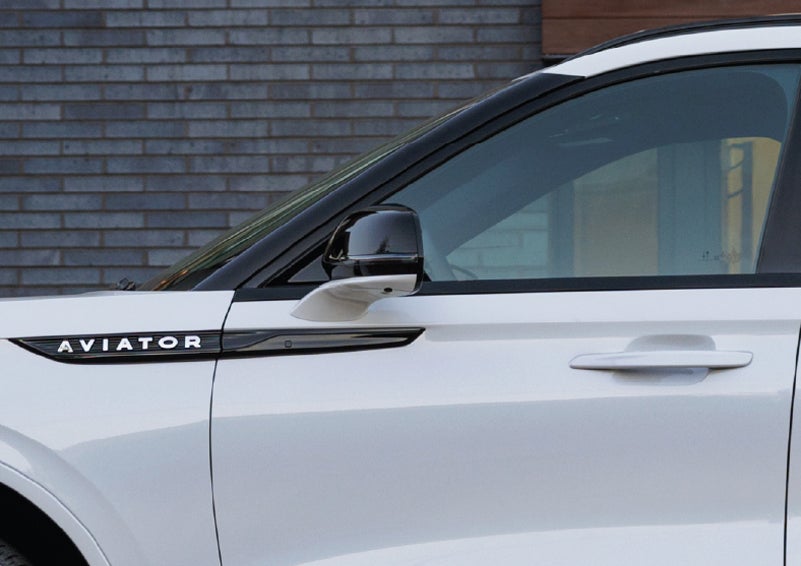 The driver’s side door and fender badging of a white 2026 Lincoln Aviator® SUV are showcased. | Star Lincoln in Southfield MI