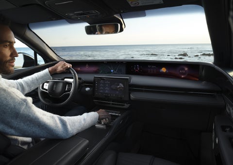 A driver of a parked 2026 Lincoln Nautilus® SUV takes a relaxing moment at a seaside overlook while inside his Nautilus. | Star Lincoln in Southfield MI