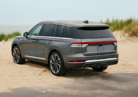 A 2027 Lincoln Aviator® SUV is parked next to sand dunes. | Star Lincoln in Southfield MI