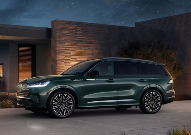 A green 2027 Lincoln Aviator® SUV is parked outside a contemporary home. | Star Lincoln in Southfield MI