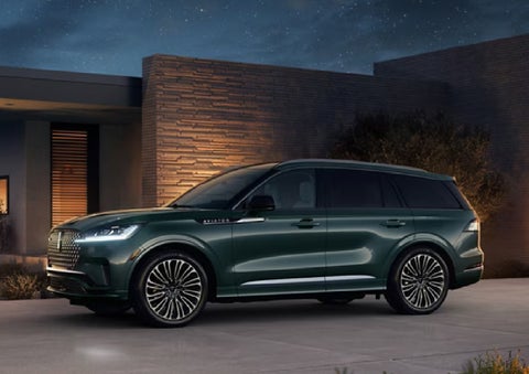 A green 2027 Lincoln Aviator® SUV is parked outside a contemporary home. | Star Lincoln in Southfield MI