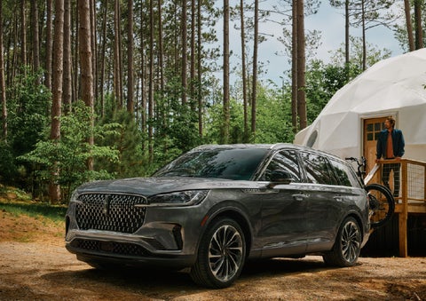 A 2027 Lincoln Aviator® is parked next to a high end glamping site. | Star Lincoln in Southfield MI