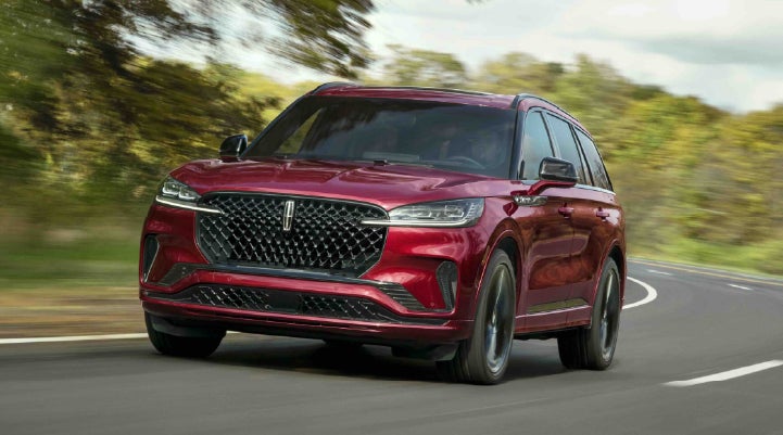 A 2027 Lincoln Aviator® SUV is being driven on a country road | Star Lincoln in Southfield MI